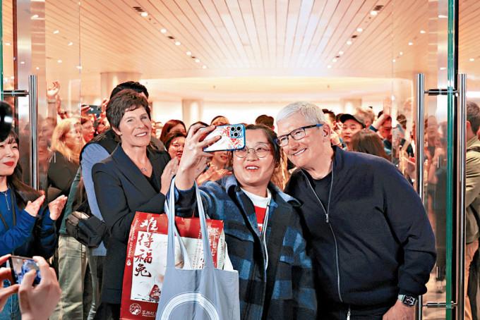 蘋果行政總裁庫克周四在上海蘋果靜安零售店開業儀式上，與顧客合照。
