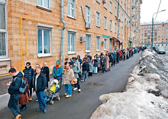 周日正午，大批选民挤在莫斯科一个投票站外排队投票。　
