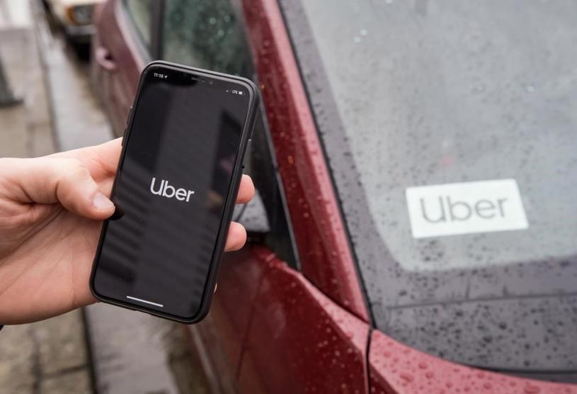 The Uber app is seen on an iPhone near a driver's vehicle after the company launched service, in Vancouver, Friday, Jan. 24, 2020. Uber Technologies Inc. drivers, couriers and passengers in Canada will be required to wear a mask starting Monday. THE CANADIAN PRESS/Darryl Dyck